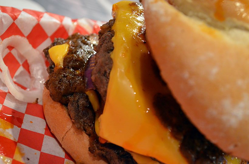 Queijo chedar, dois hamburguers generosos, algumas cebolinhas perdidas