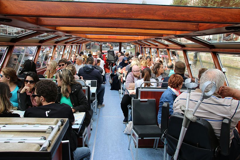 Interior da embarcação que leva os visitantes pelos canais de Amsterdam
