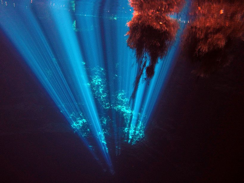 Raios de luz solar adentram a escuridão da piscina natural