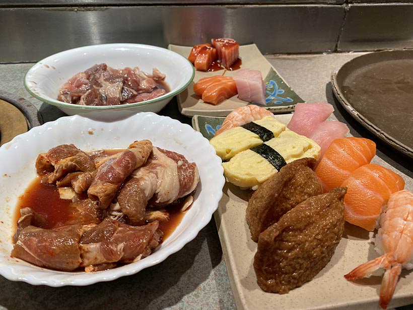 Sushiman trabalha em frente a várias tiras de salmão